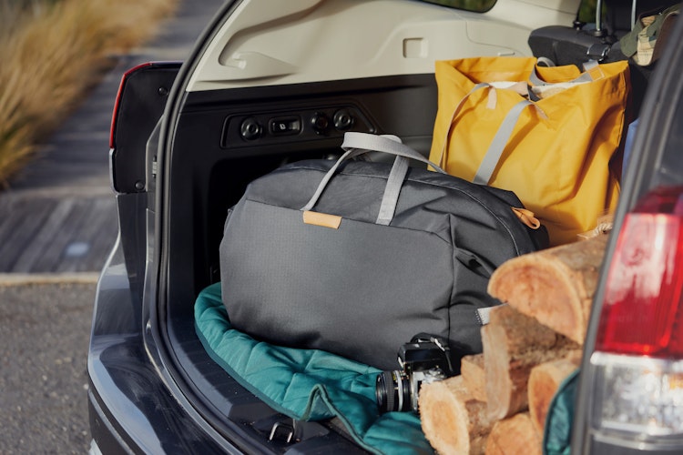 Bellroy Classic Weekender 45L duffel in recycled ripstop shown in a packed car trunk, ready for adventure with outdoor gear.
