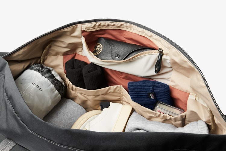 Bellroy Classic Weekender 45L in slate, open to show the organized contents, and pockets with ribba fabric highlighting the storage features.