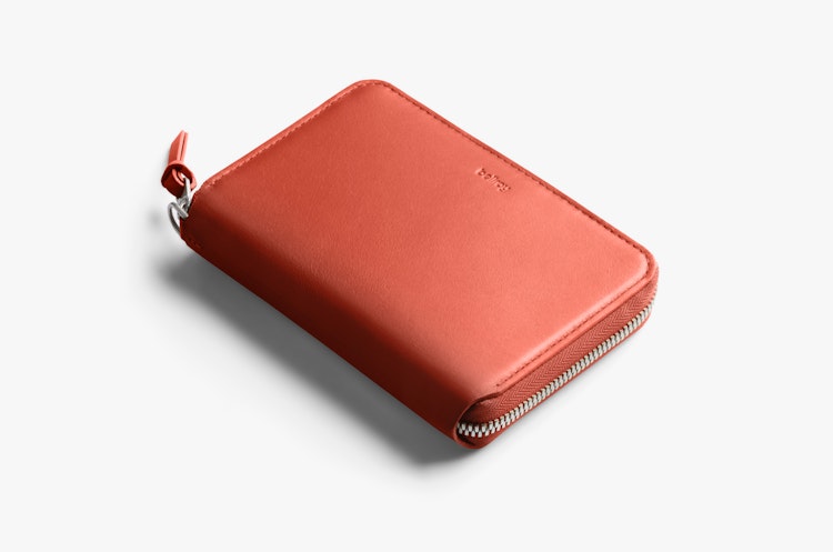Closed blood orange leather Bellroy Folio Wallet with RFID protection, zip closure, and embossed logo displayed on a white background.