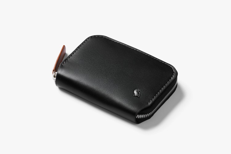 Black leather Bellroy Folio Mini RFID wallet with brown zipper pull and metallic logo, shown on a white background for product display.