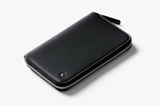 Black leather Bellroy Travel Folio wallet with RFID protection, zip closure, and subtle logo, displayed on a plain white background.